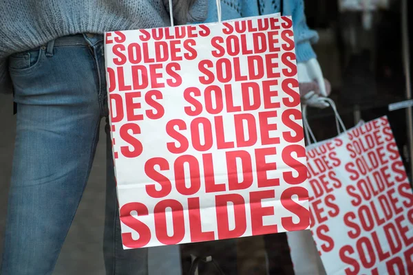 法国的折扣牌 Soldes 在法国的纸袋上诱拐冬季服装背景的时装店陈列室 — 图库照片