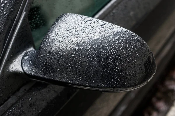 雨落在停在街上的黑色汽车的镜子上 — 图库照片