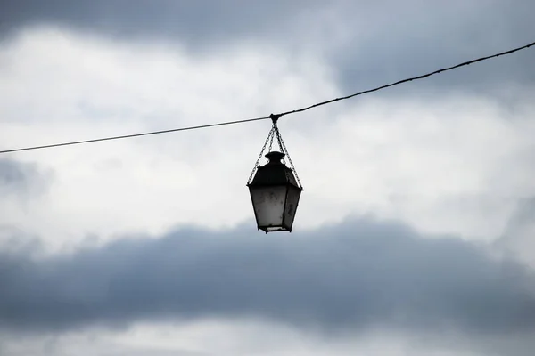 구름낀 하늘을 배경으로 거리의 케이블 매달려 스러운 가로등을 클로즈업 — 스톡 사진