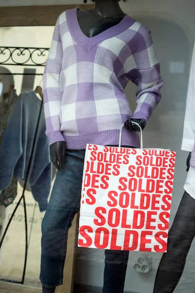 法国的折扣牌 Soldes 在法国的纸袋上诱拐冬季服装背景的时装店陈列室 — 图库照片