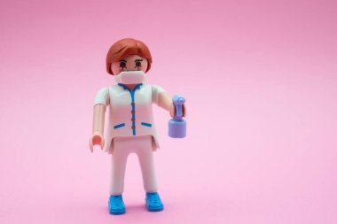 Mulhouse - Fransa - 9 Aralık 2020 - Yüz maskesi ve pembe arka planda hidroterapi jeli oyun gezer karaktere yakın çekim