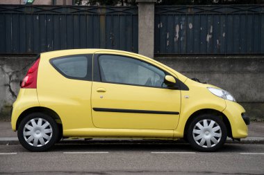 Mulhouse - Fransa - 27 Şubat 2021 - Sokakta park edilmiş sarı Peugeot 107 'nin profil görüntüsü