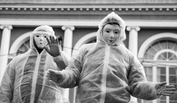 Portrait of people wearing a chemical clothes and carnaval mask  protesting against the sanitary dictatorship , anti masks and anti vaccine people with anonymous  costume in the street