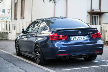 Mulhouse - Fransa - 27 Mart 2021 - Caddeye park edilmiş mavi BMW 330i 'nin ön görüntüsü 