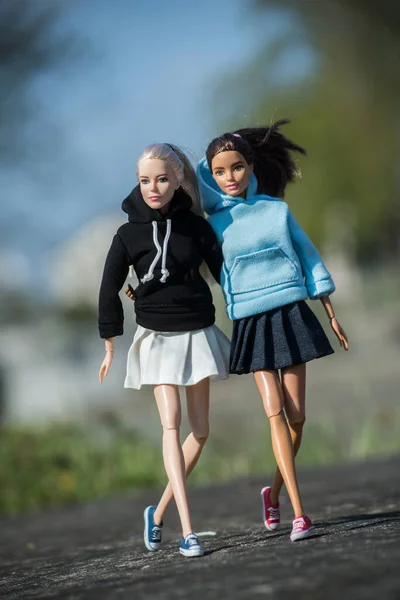 2021年4月17日 两个身穿汗衫和学校女生裙的芭比娃娃在街上行走的肖像 — 图库照片
