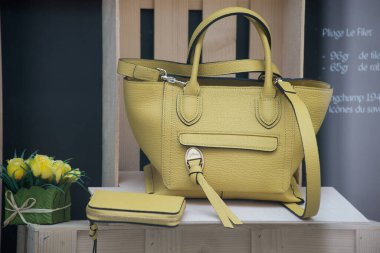 Mulhouse - France - 24 May 2021 - Closeup of yellow leather handbag by Longchamp in a luxury fashion store showroom 