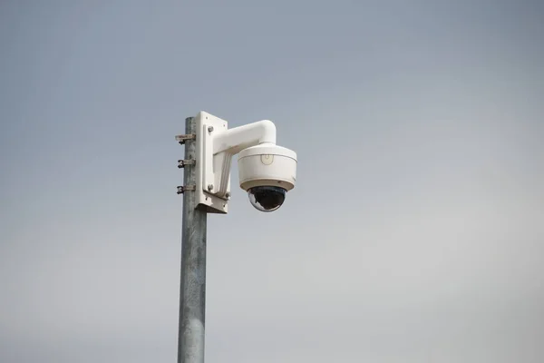 closeup of isolated security camera on cloudy sky background