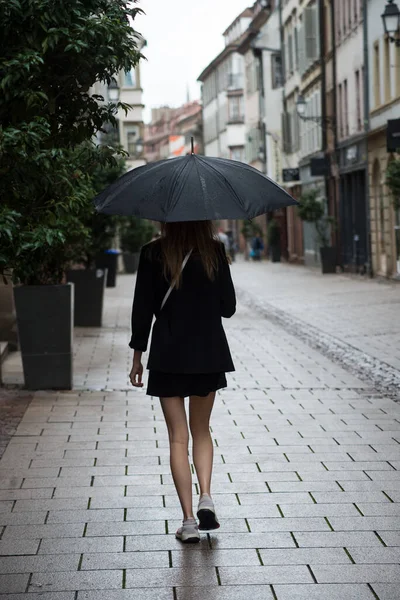 Portret Achteraanzicht Van Meisje Wandelen Straat Met Een Zwarte Paraplu — Stockfoto