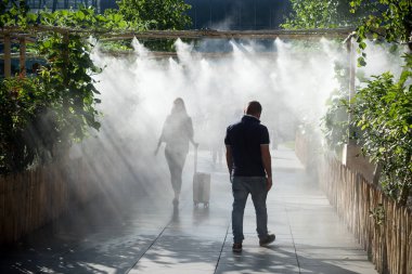 Şehir parkında sprey ile gezen insanların portresi