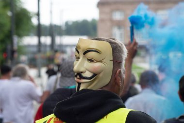 Mulhouse - Fransa - 24 Temmuz 2021 - Kafasında isimsiz maskeyle sokakta protesto yapan insanların portresi