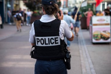 Colmar - Fransa - 4 Eylül 2021 - Sokakta duran Fransız polis kadının arka plandaki portresi  