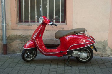 Colmar - Fransa - 18 Eylül 2021 - Sokağa park edilmiş kırmızı Vespa scooter profili 