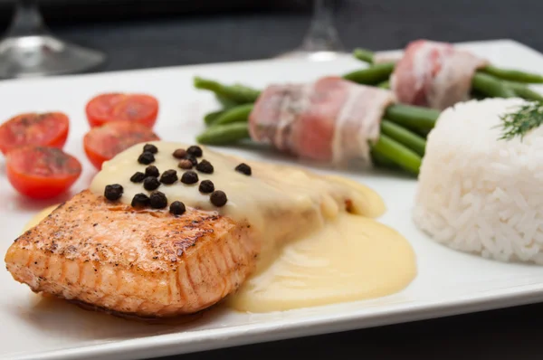 Salmon steak with hollandaise sauce and rice cherry tomatoes and green beans