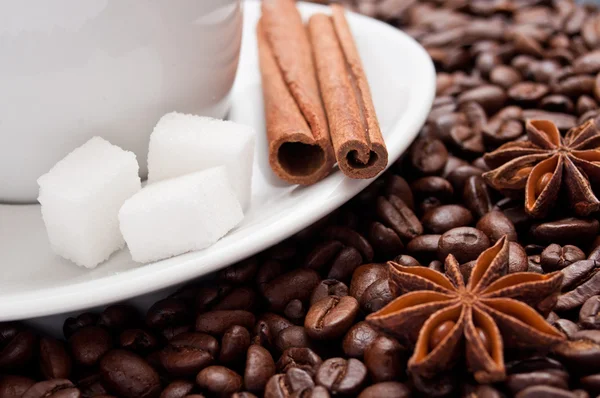 Kopje koffie met gedroogde anis en kaneel op bonen achtergrond — Stockfoto