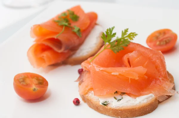 Présentation de pain grillé au saumon avec tomates cerises — Photo