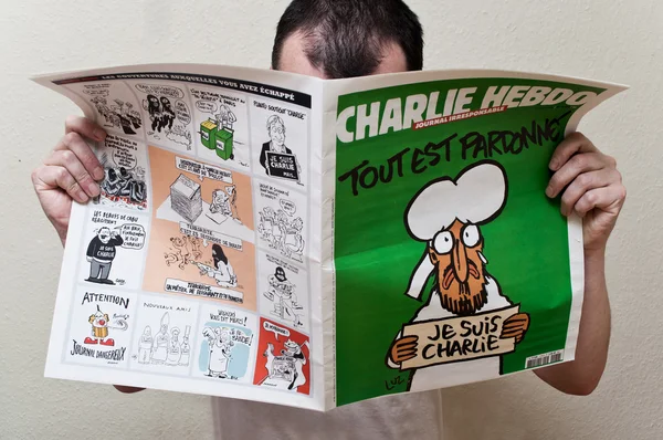 Paris - Frankrijk - 14 januari 2015 - man leest het blad Charlie Hebdo de editie van 14 januari 2015 na de aanval van het terrorisme, op januari 7, 2015 in Parijs — Stockfoto