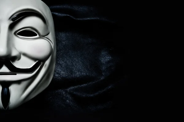 París - Francia - 18 de enero de 2015 - Máscara Vendetta sobre fondo negro. Esta máscara es un símbolo bien conocido para el grupo hacktivista en línea Anónimo — Foto de Stock