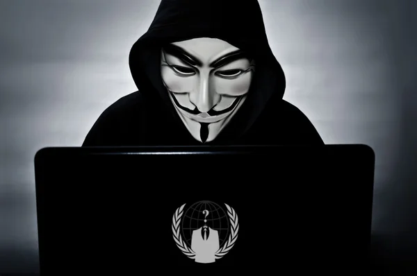 Anonymes Mitglied mit Computer mit Vendetta-Maske — Stockfoto