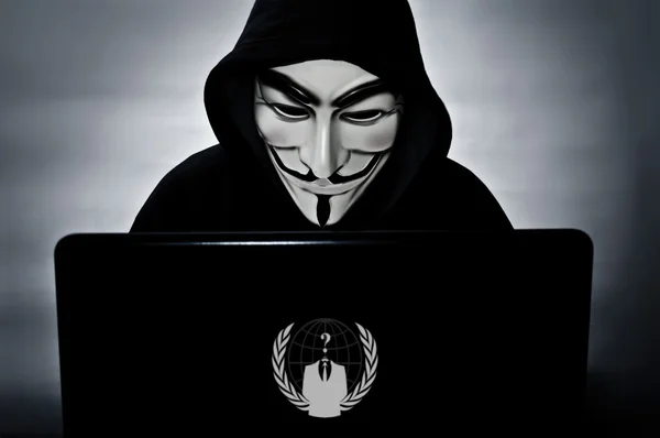 Anonieme lid met de computer met het masker vendetta Rechtenvrije Stockfoto's