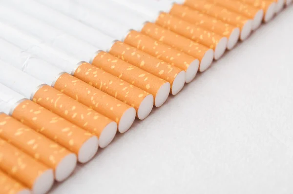 Alinhamento de cigarros no fundo branco — Fotografia de Stock