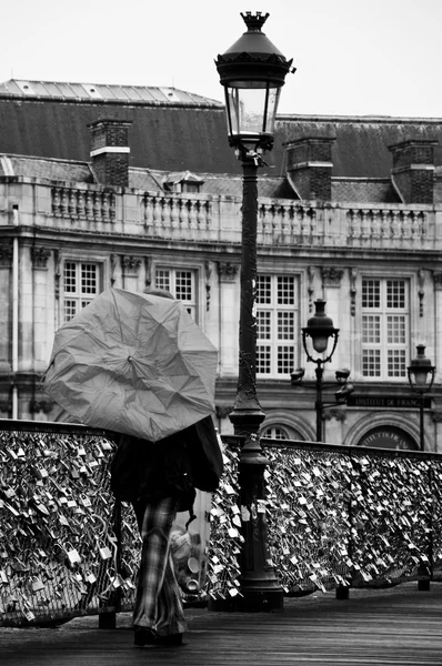 PARÍS - Francia - 10 de junio de 2012 - turista con sombrilla por día lluvioso en el puente de las Artes en París — Foto de Stock