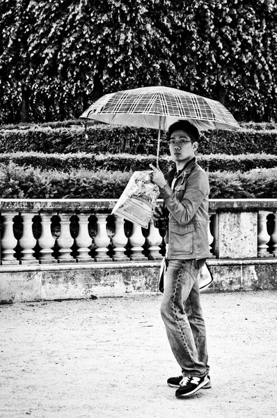 PARIS - França - 10 de junho de 2012 - turista chinês com guarda-chuva por dia chuvoso no jardim das Tulherias — Fotografia de Stock