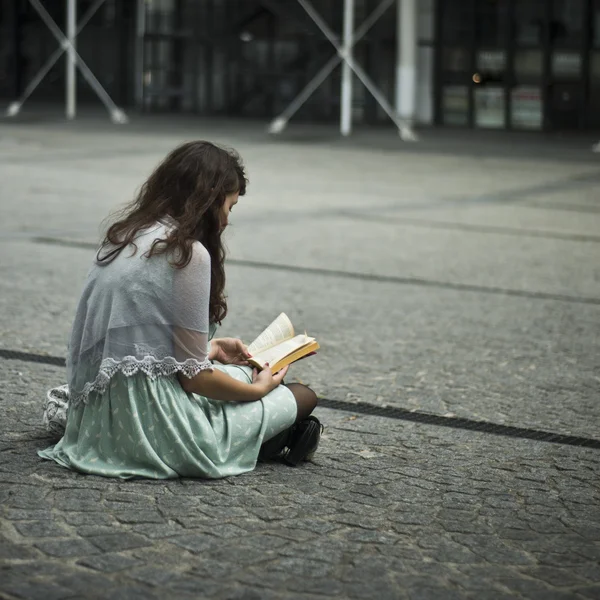 Paris - frankreich - 7 august 2012 - frau sitzt mit buch in wunderschönen platz — Stockfoto