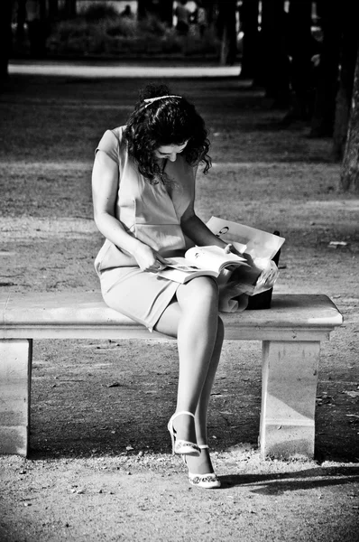 PARÍS - Francia - 17 de junio de 2012 - Mujer con vestido blanco leyendo en el jardín de las Tullerías — Foto de Stock