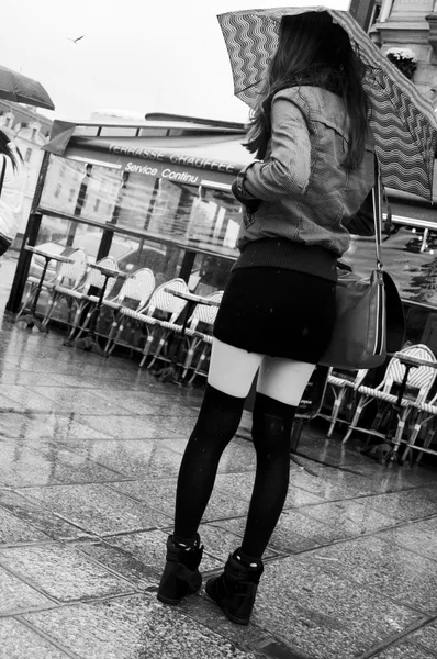 PARIS - France - 1 November 2013 - woman with mini skirt waiting with umbrella — Stock Photo, Image