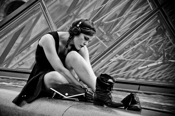 PARIS - France - 17 juin 2012 - femme assise près de la pyramide du Louvre — Photo