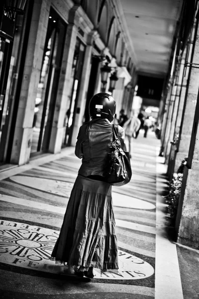 PARIGI - Francia - 30 luglio 2012 - donna con casco da moto passeggia sotto una galleria coperta — Foto Stock