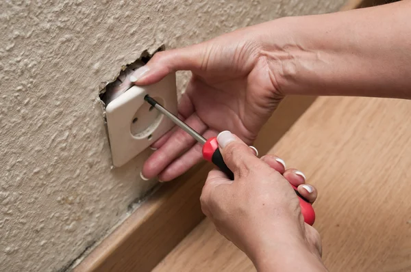 Woman changing a electrical outlet — Stock Photo, Image