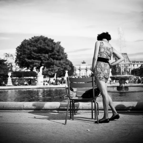 Donna con abito in piedi vicino alla sedia nel giardino Tuilerie a Parigi — Foto Stock