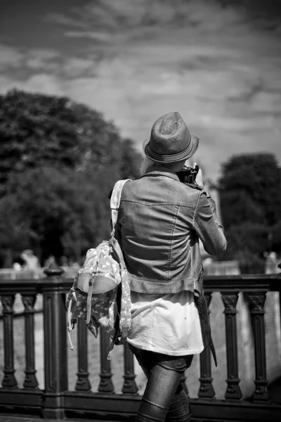 Turista con sombrero tomar una foto en el río Sena frontera en París — Foto de Stock