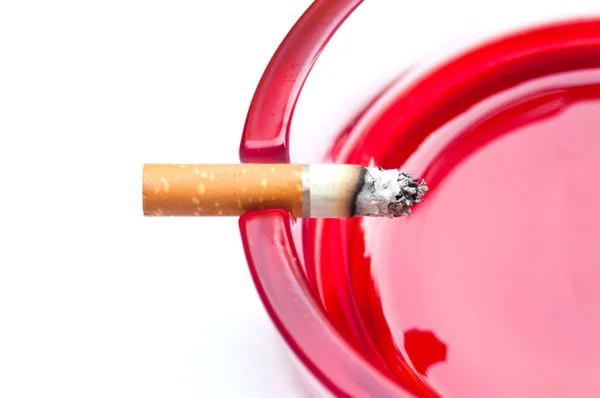 Último cigarro na borda do cinzeiro vermelho — Fotografia de Stock