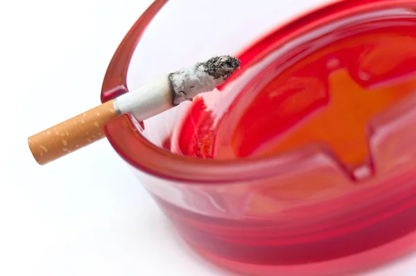 Último cigarro na borda do cinzeiro vermelho — Fotografia de Stock