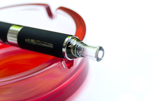 E-cigarette on red ashtray on white background
