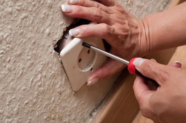 Woman changing a electrical outlet — Stock Photo, Image