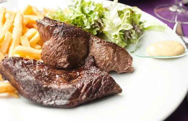 Стейк из говядины и салат из картошки фри в ресторане — стоковое фото