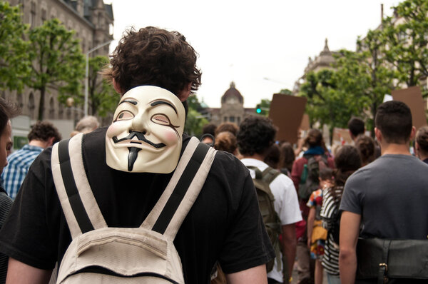 СТРАСБУРГ - Франция - 23 мая 2015 года - люди в анонимной маске во время демонстрации против Монсанто и трансатлантического лечения для производства ГМО в Европе
 -