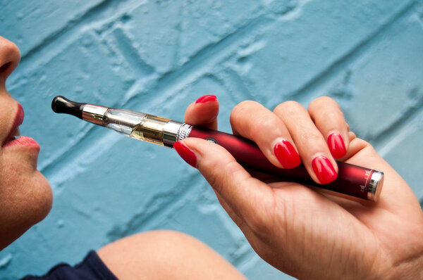 Closeup woman with e-cigarette in outdoor