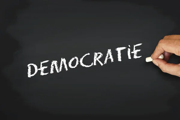 Концепция написания с шалком на доске - democraty democraty по-французски — стоковое фото