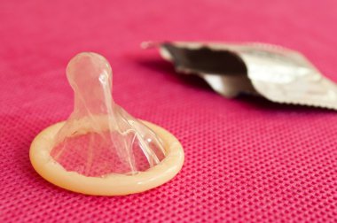 Prezervatif pembe bir arka plan üzerinde