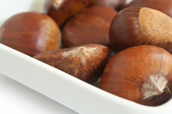 Closeup group of chestnuts in a bowl on white background Stock Photo