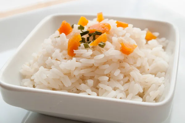 Tigela de arroz com ervas decorativas e cenouras — Fotografia de Stock