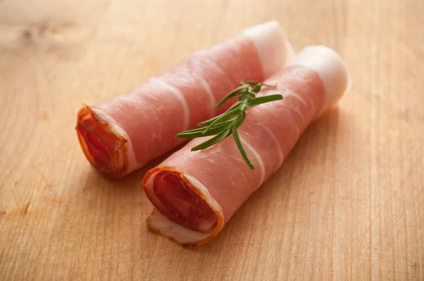 Closeup of italian raw ham on wooden cuting board — Stock Photo, Image