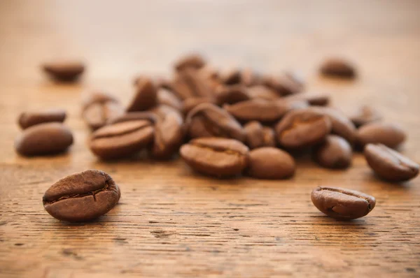 Close-up de grãos de café no fundo de madeira — Fotografia de Stock