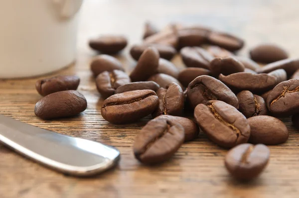 Close-up van een kop van koffie en koffiebonen op houten achtergrond — Stockfoto