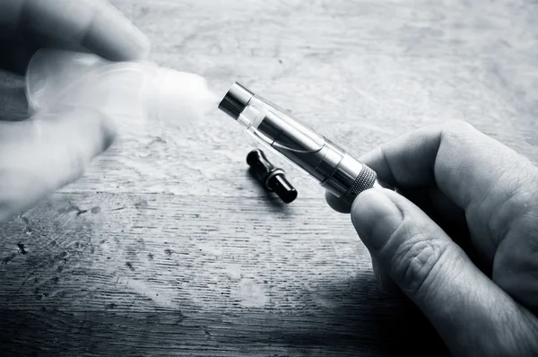 Closeup of e-cigarette  filling on wooden background — Stock Photo, Image