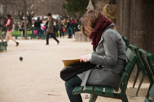 Vrouw leest op Bank in Notre dame tuin — Stockfoto